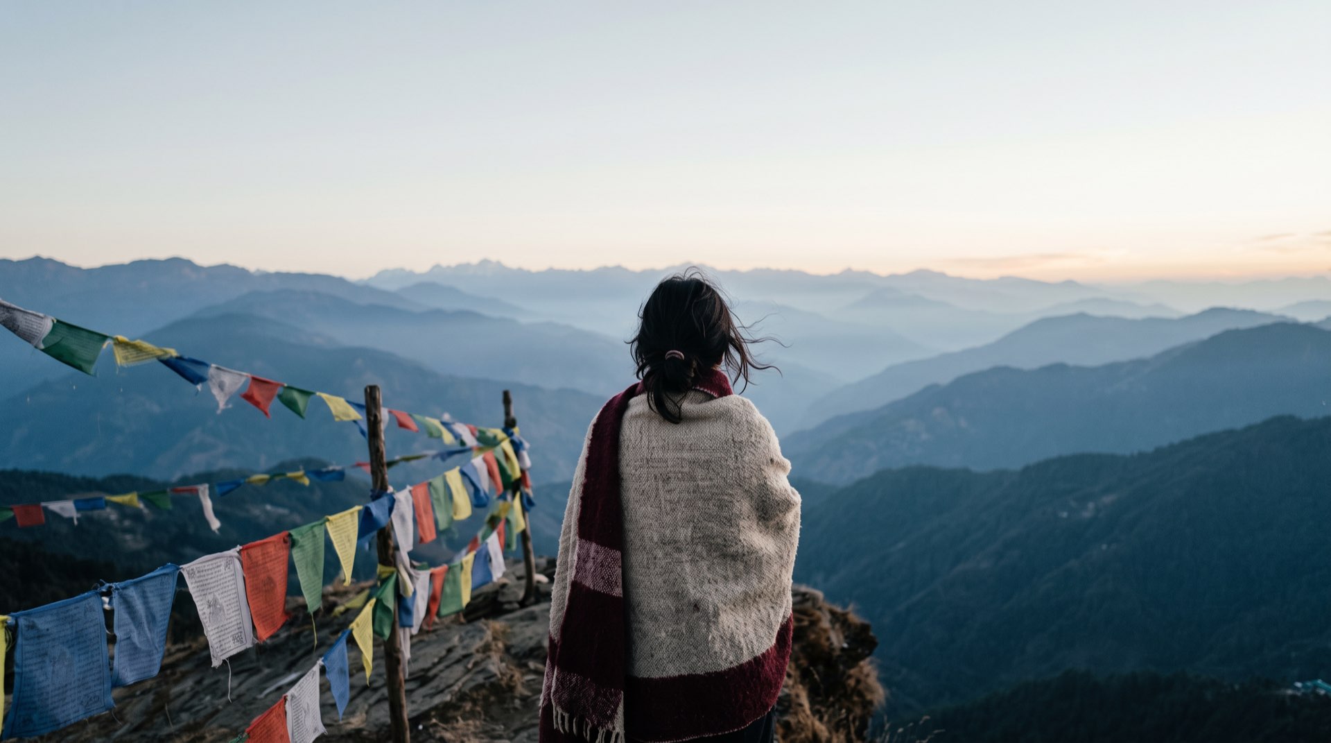 A traveller looking over layered ridges at dawn