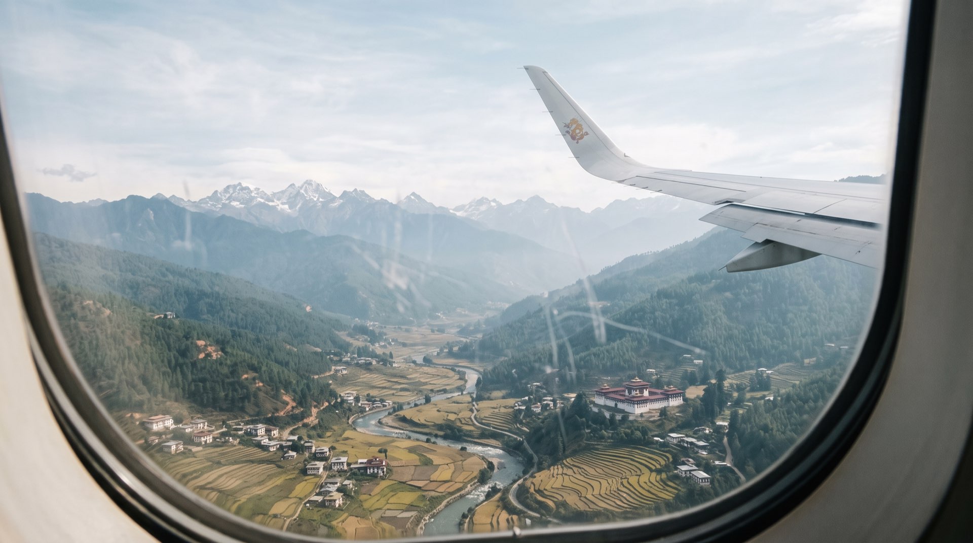 Aeroplane window view over a forested Himalayan valley