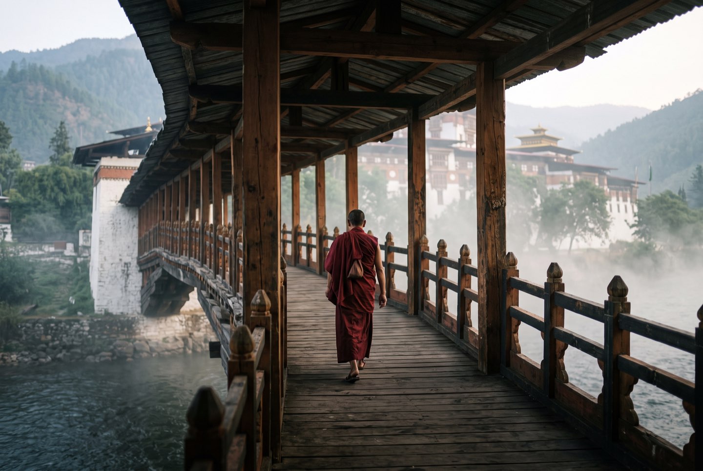 A lone figure crossing the bridge at Punakha Dzong in morning mist