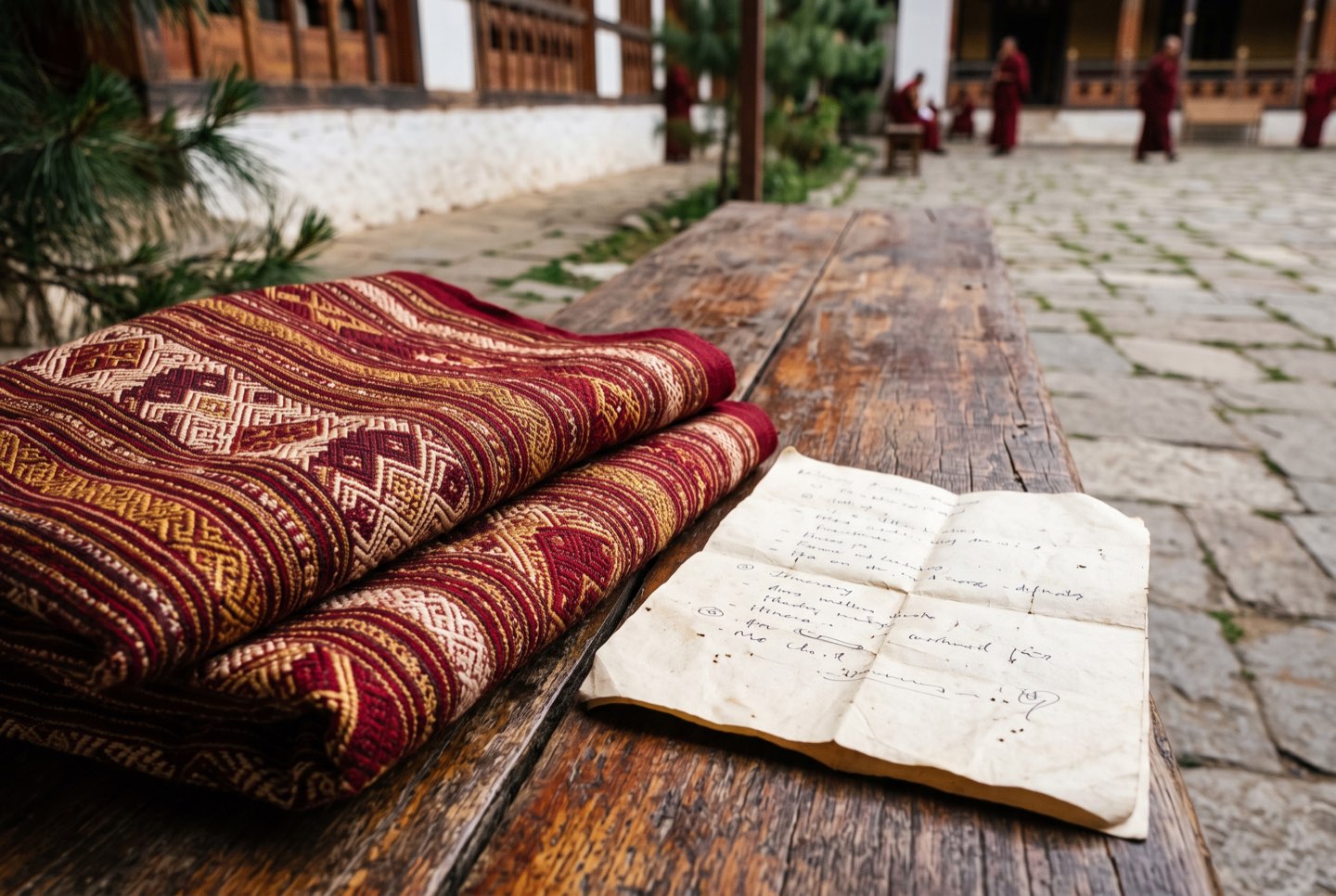 Hand-woven textile beside a handwritten itinerary